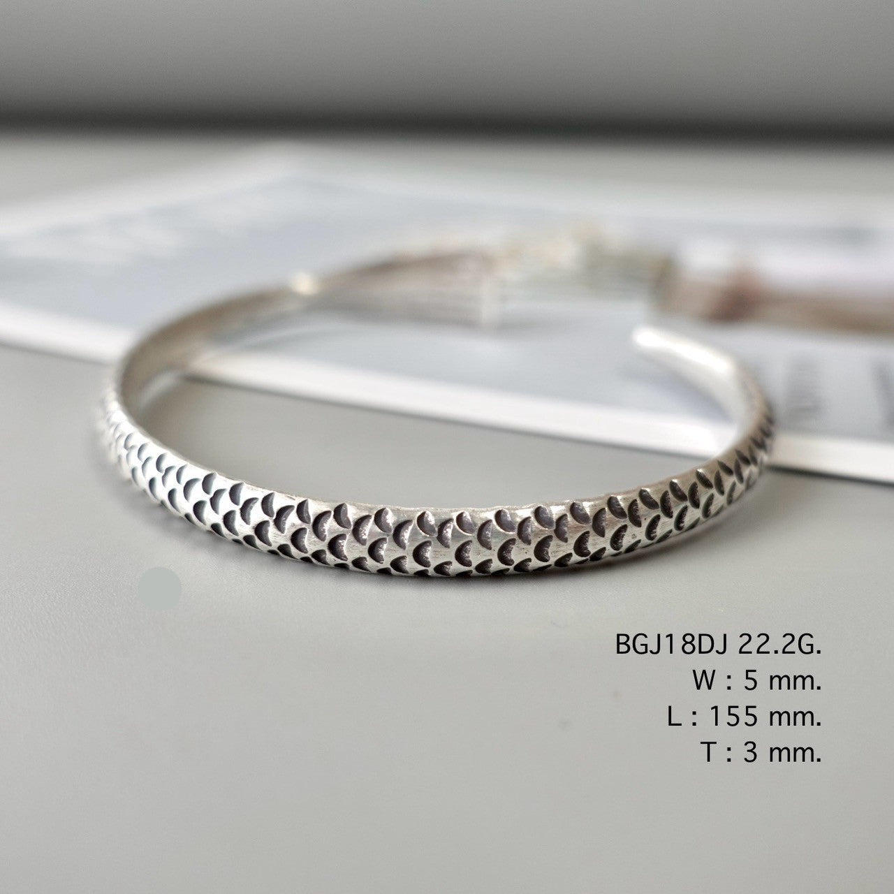 Silver bangle, artisan-crafted perfection.
